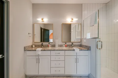 a bathroom with a granite countertop sink a toilet and shower