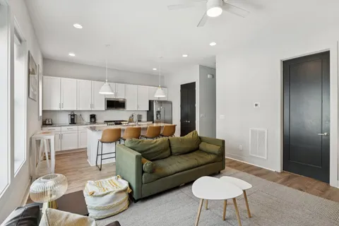 a living room with furniture and a view of kitchen