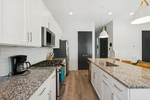 a kitchen with stainless steel appliances granite countertop a sink stove and refrigerator
