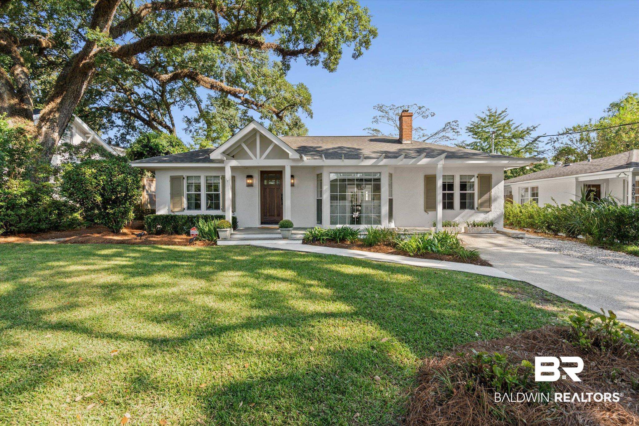4310 The Cedars Avenue Mobile, AL 36608 - Photo 1 of 32 View of front of home with a chimney, a front yard, a porch, and stucco siding