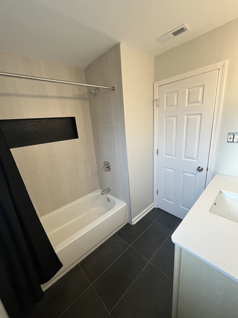 4543 West Marquette Road, Unit 2 Chicago, IL 60629 - Photo 12 of 12 a bathroom with a sink a toilet and shower