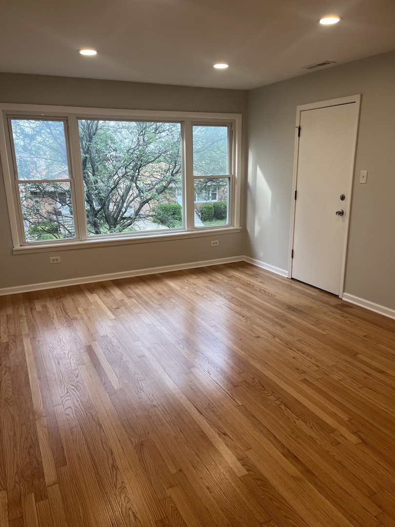 4543 West Marquette Road, Unit 2 Chicago, IL 60629 - Photo 2 of 12 an empty room with wooden floor and a window