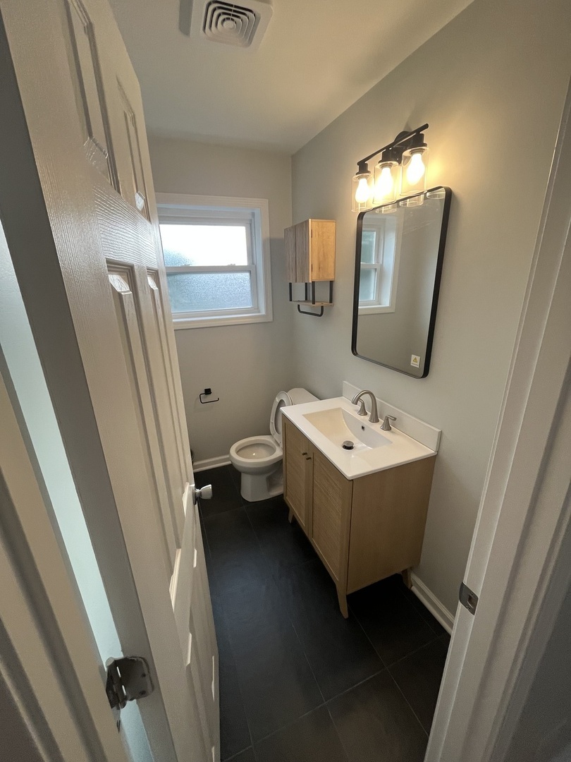 4543 West Marquette Road, Unit 2 Chicago, IL 60629 - Photo 10 of 12 a bathroom with a sink toilet and mirror