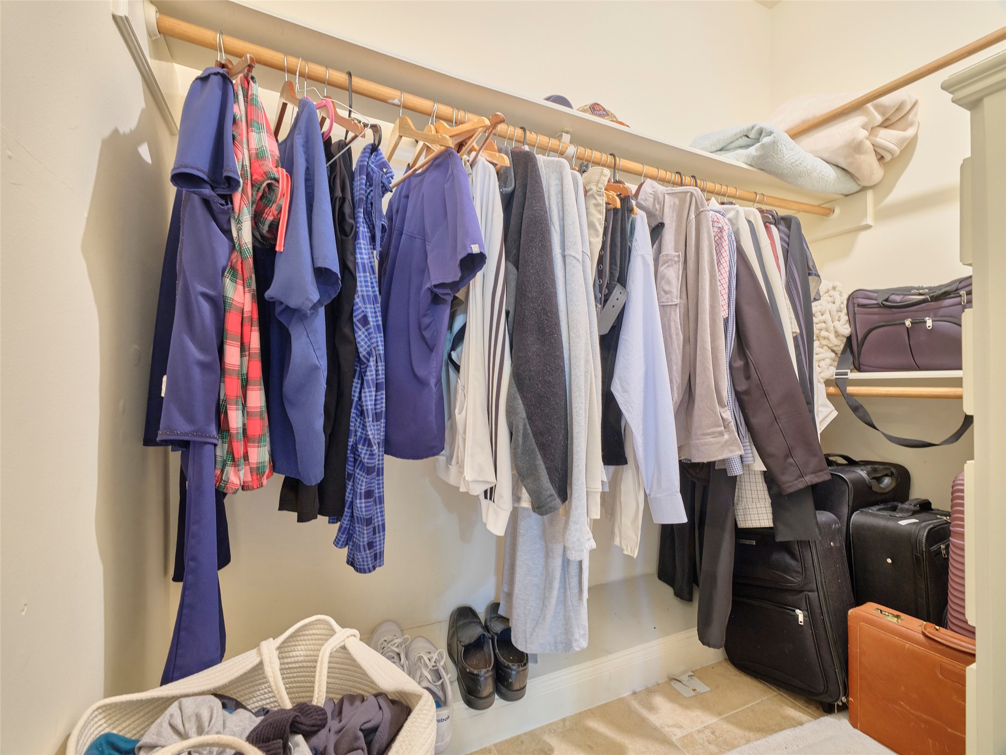 16623 Manningtree Lane Spring, TX 77379 - Photo 25 of 39 Spacious walk-in closet with ample hanging space for clothes, shelves for accessories, and room for suitcases, making it ideal for organized storage.