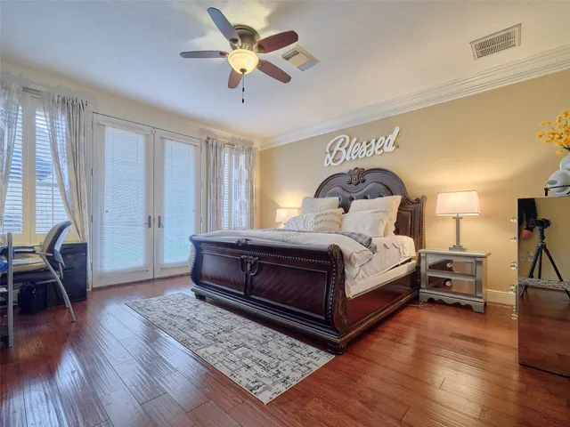 a bedroom with a bed a chandelier and dresser