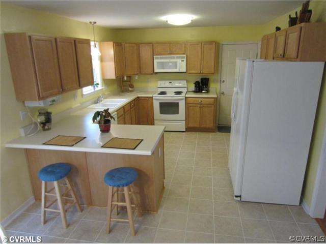 3508 Pease Road Midlothian, VA 23112 - Photo 3 of 12 a kitchen with stainless steel appliances a stove a refrigerator a sink a dining table and chairs