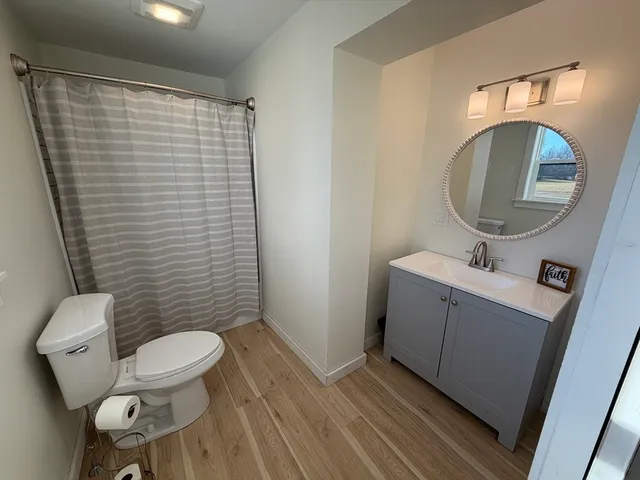a bathroom with a toilet a sink and mirror