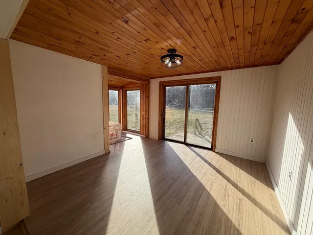 a view of a hall with wooden floor and windows