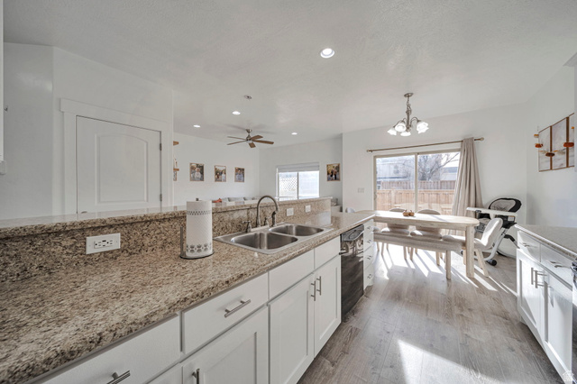 11730 South Shadow Lane Draper, UT 84020 - Photo 9 of 24 Kitchen featuring white cabinets, light wood-type flooring, a chandelier, light stone countertops, and ceiling fan
