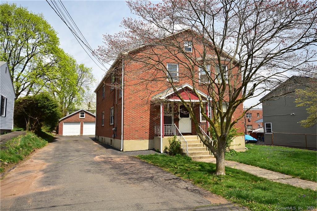 180 Rhodes Street New Britain, CT 06051 - Photo 1 of 1 a front view of a house with a yard and garage