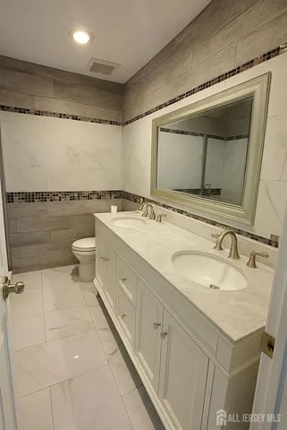 a bathroom with a granite countertop sink mirror and double
