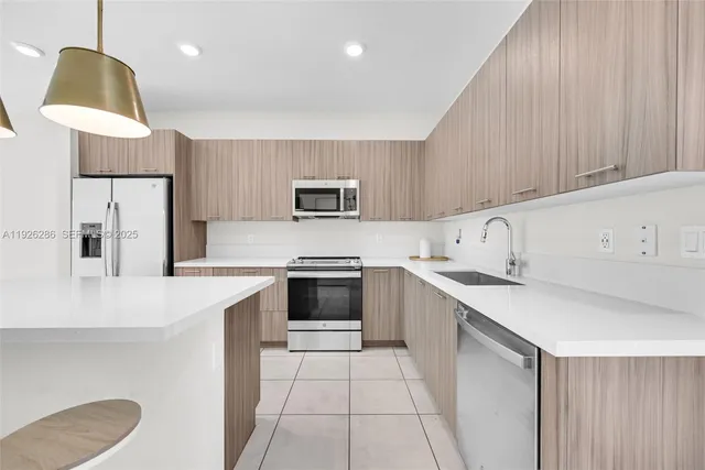 a kitchen with kitchen island a counter top space appliances and cabinets