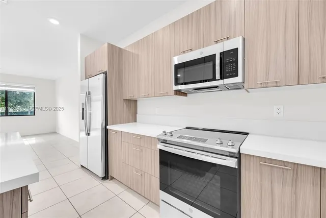 a kitchen with stainless steel appliances a sink stove and white cabinets