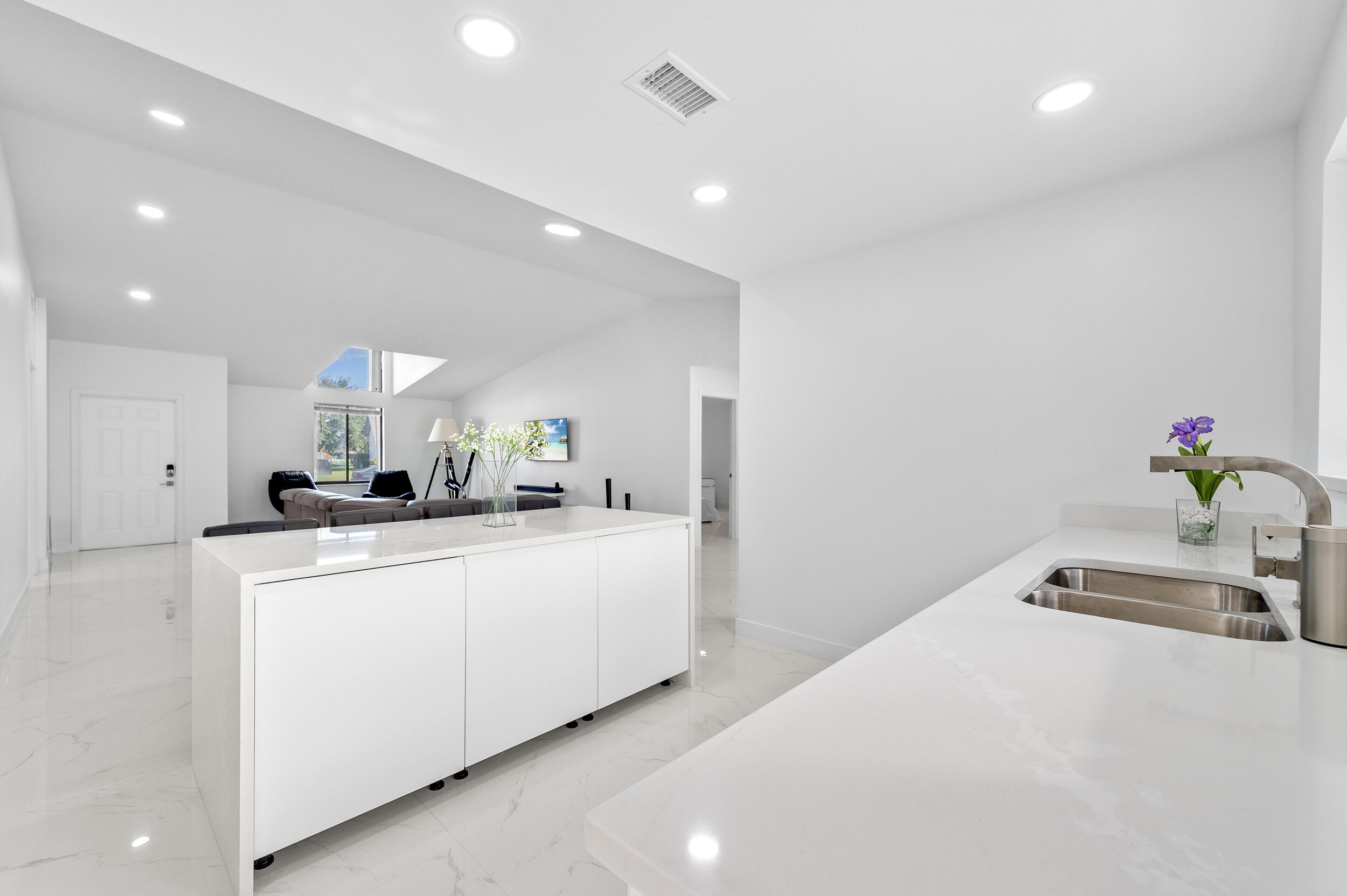 22301 Ensenada Way Boca Raton, FL 33433 - Photo 18 of 44 a large white kitchen with sink a microwave and white cabinets