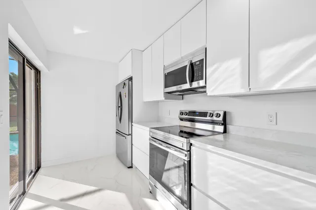 a kitchen with stainless steel appliances granite countertop a refrigerator stove and microwave