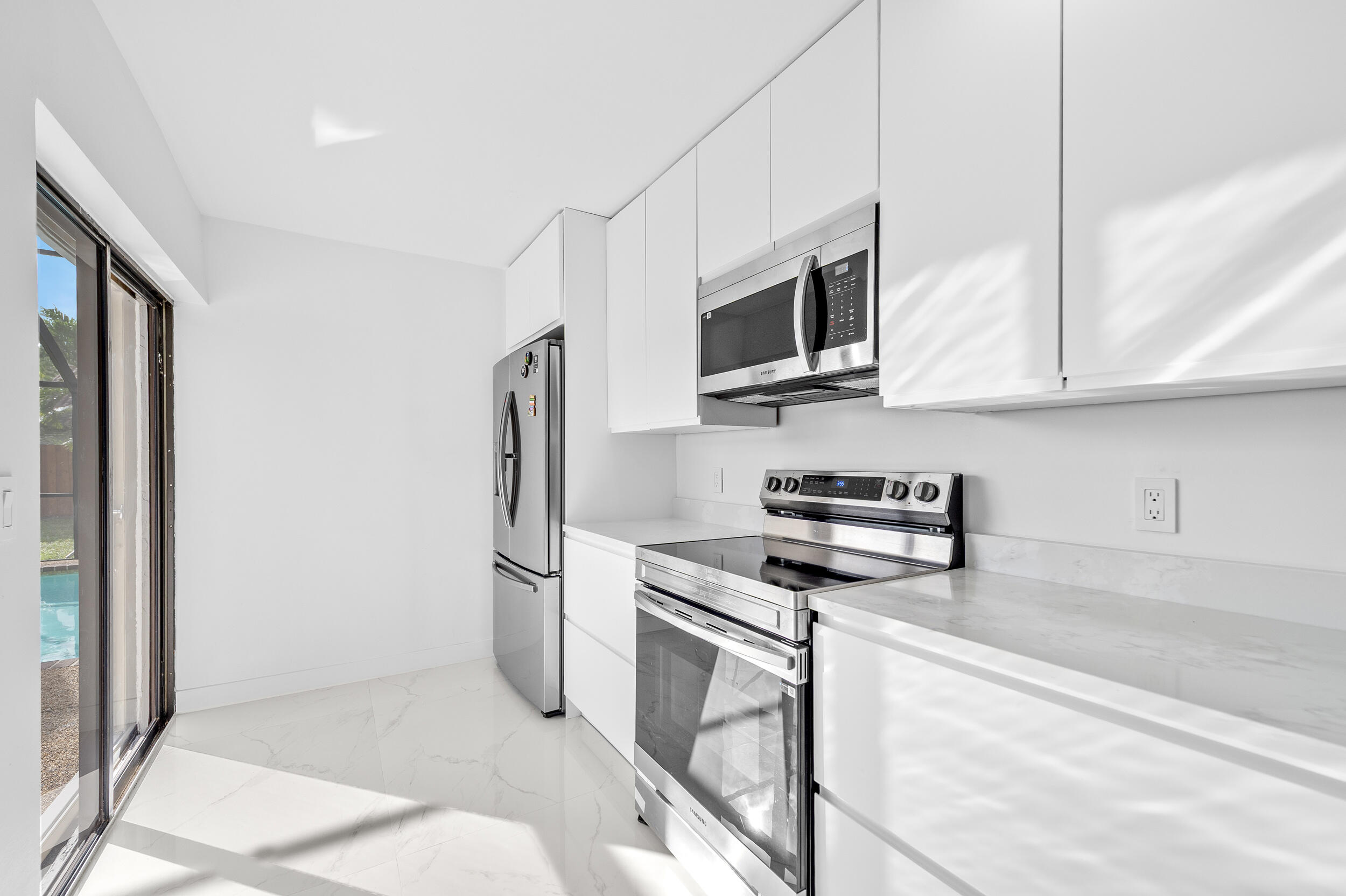 22301 Ensenada Way Boca Raton, FL 33433 - Photo 19 of 44 a kitchen with stainless steel appliances granite countertop a refrigerator stove and microwave
