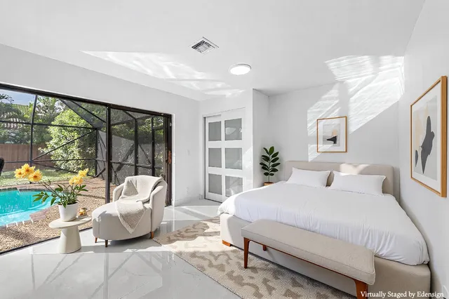 a bedroom with a large window and a potted plant