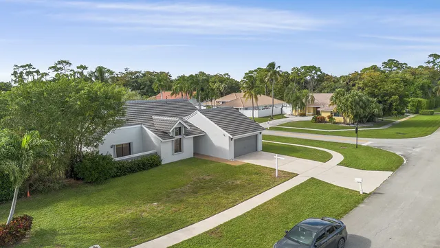 an aerial view of a house with swimming pool garden and trees