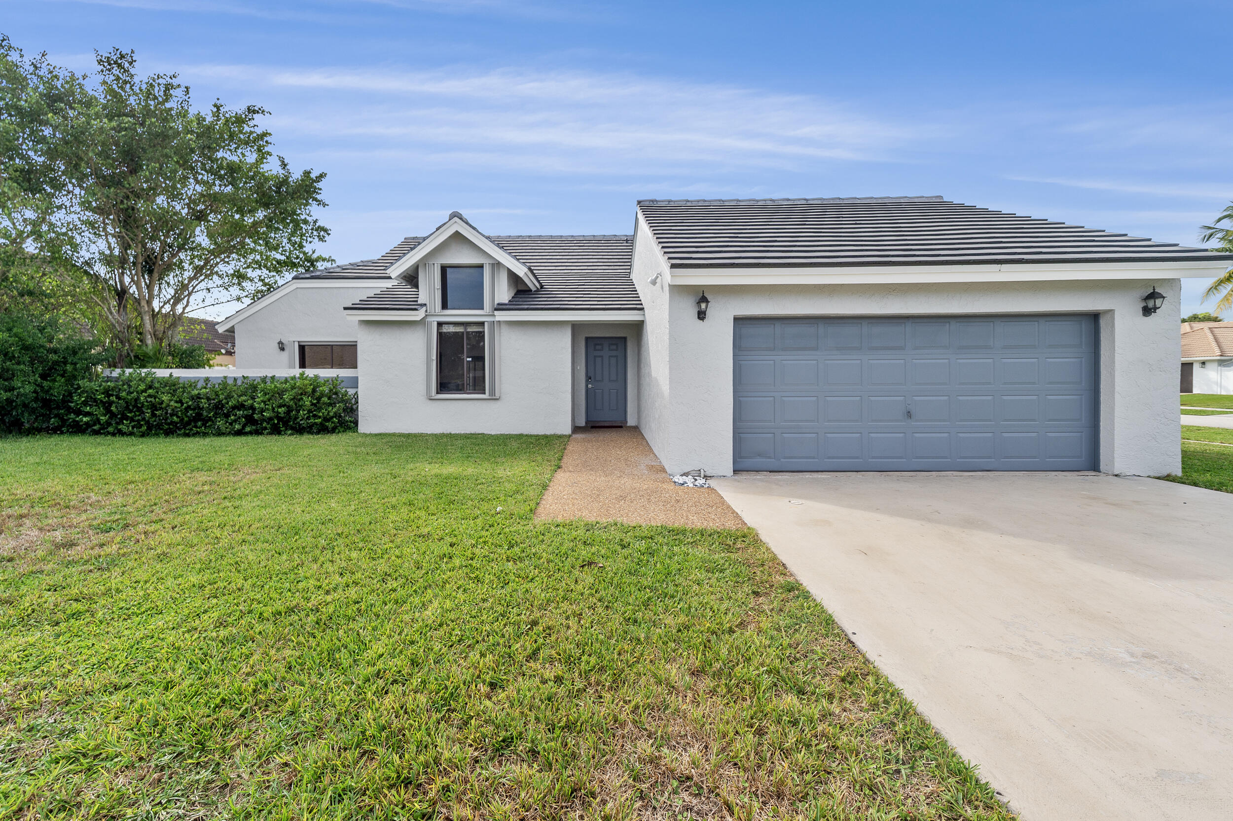 22301 Ensenada Way Boca Raton, FL 33433 - Photo 4 of 44 a front view of a house with a yard and garage