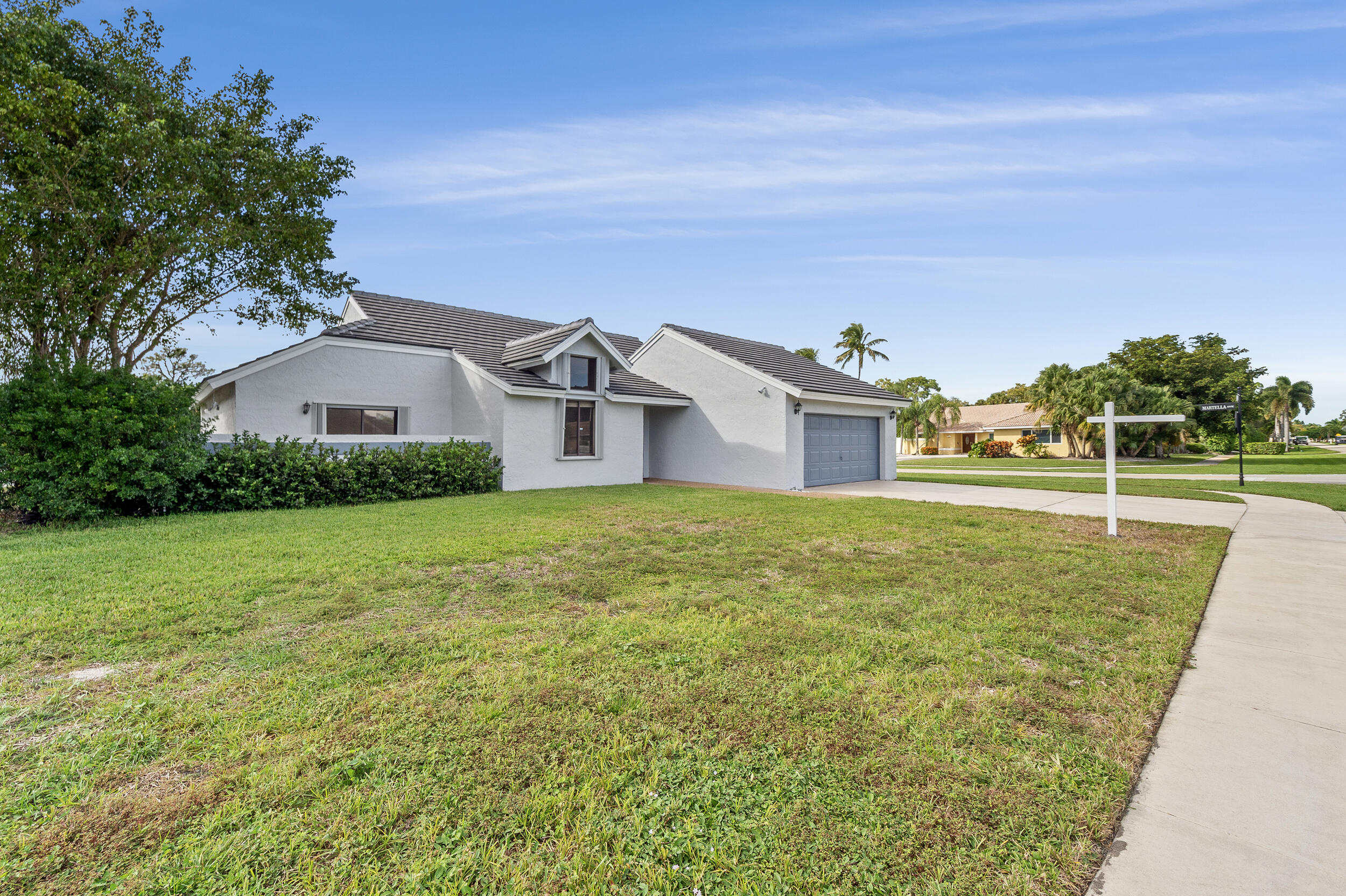 22301 Ensenada Way Boca Raton, FL 33433 - Photo 6 of 44 a front view of house with yard and trees in the background