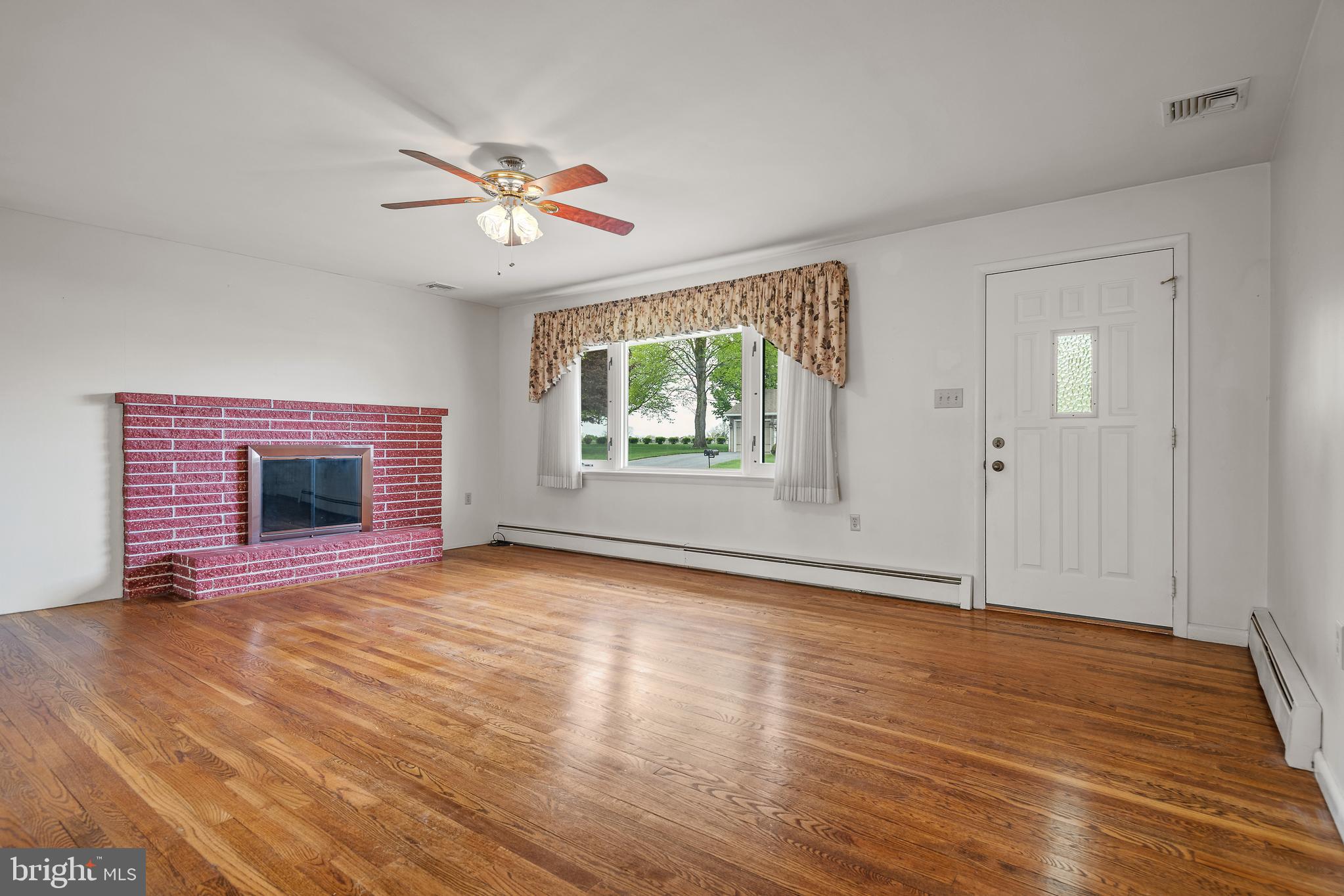 27 Pfautz Avenue Lititz, PA 17543 - Photo 6 of 25 an empty room with wooden floor chandelier fan and windows