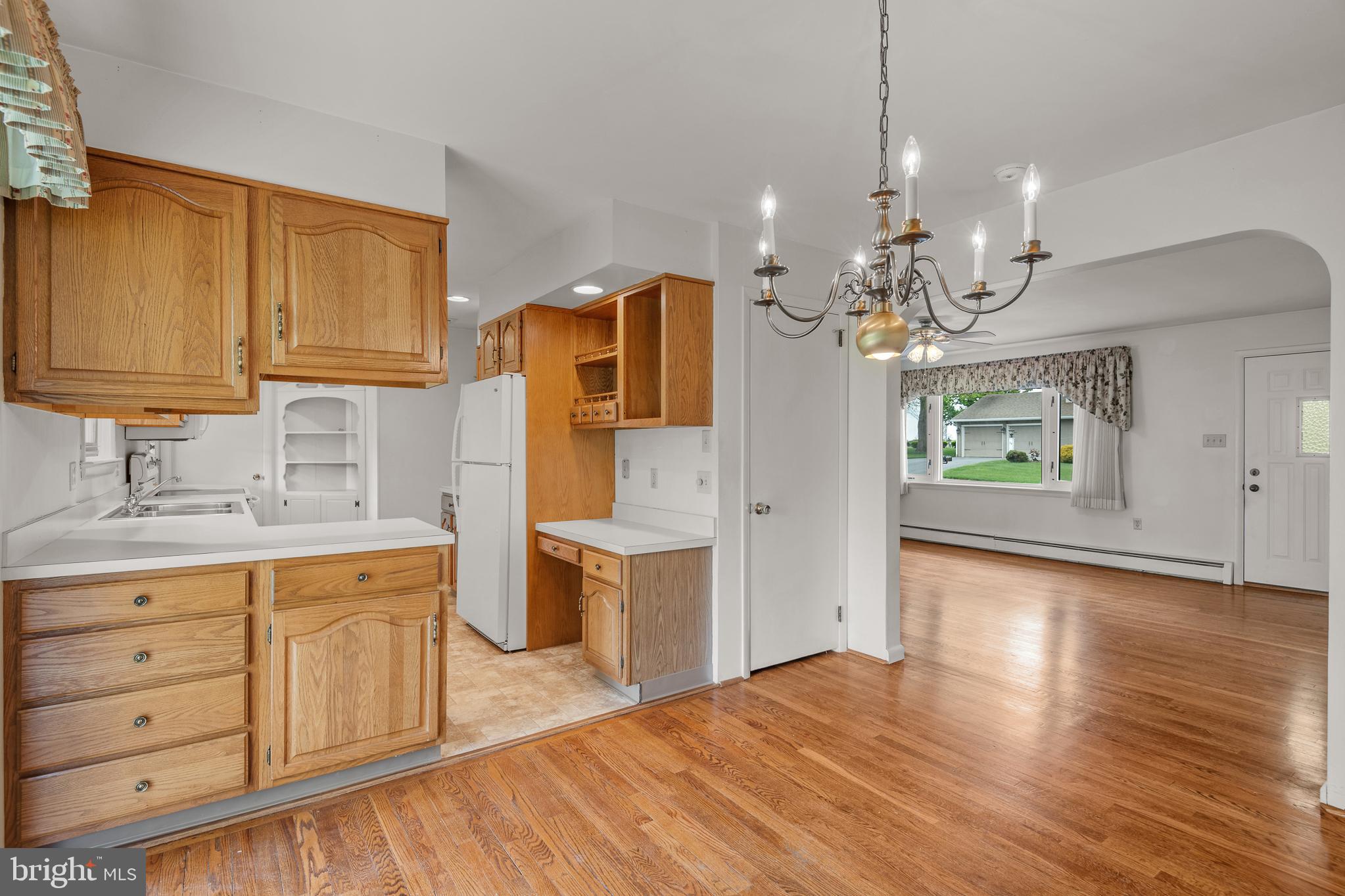27 Pfautz Avenue Lititz, PA 17543 - Photo 9 of 25 a kitchen with stainless steel appliances granite countertop a refrigerator a sink dishwasher a stove and a dining table with wooden floor