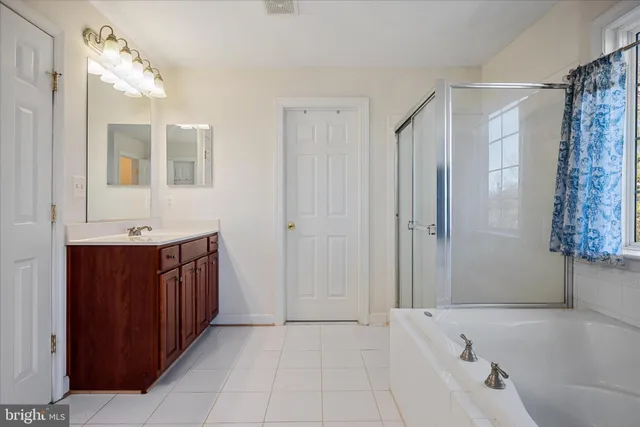a bathroom with a tub a sink and mirrors