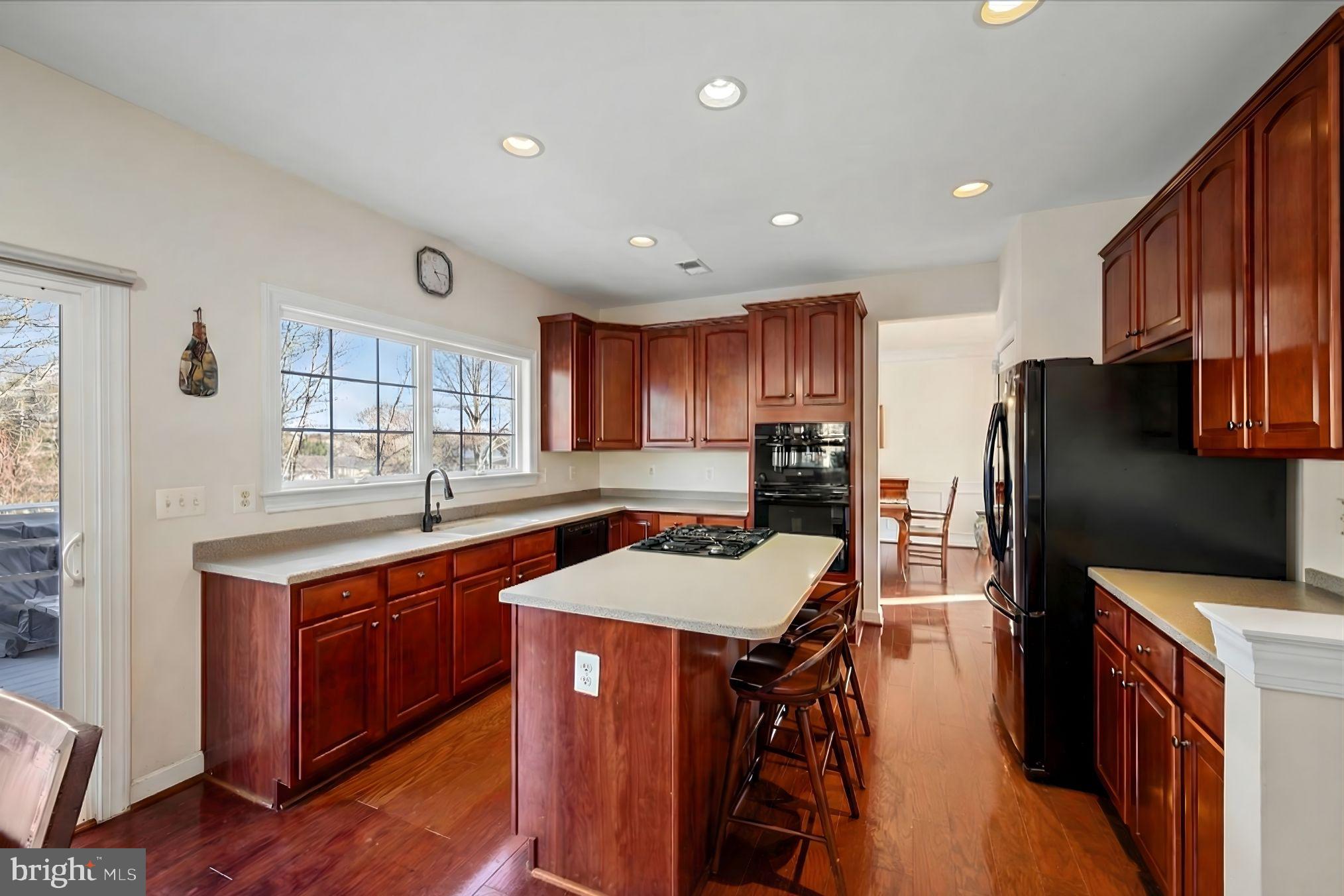 5051 Ridgeview Court Jeffersonton, VA 22724 - Photo 5 of 28 a kitchen with stainless steel appliances granite countertop a refrigerator a sink dishwasher a stove and a dining table with wooden floor
