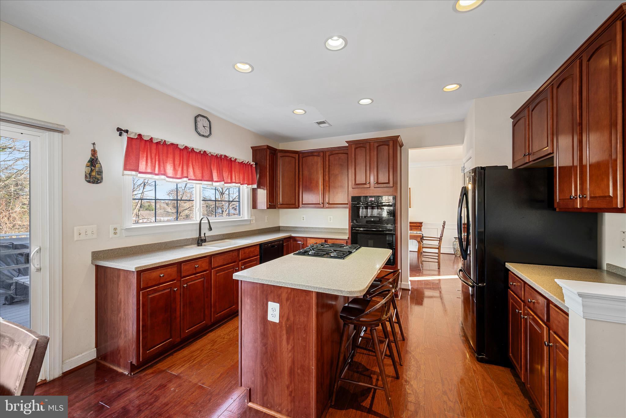 5051 Ridgeview Court Jeffersonton, VA 22724 - Photo 5 of 29 a kitchen with stainless steel appliances a sink stove refrigerator and wooden cabinets