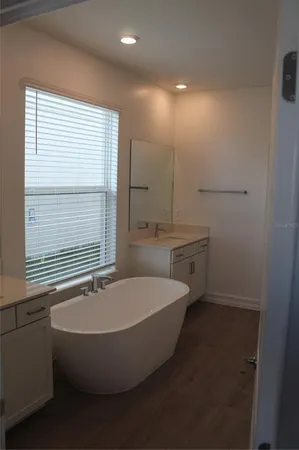 a white bath tub sitting in a bathroom next to a window