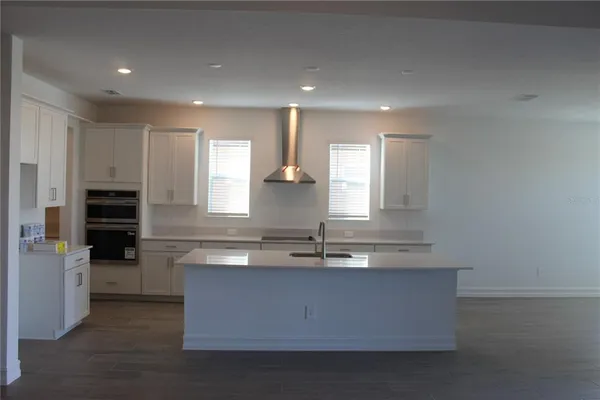 a kitchen with kitchen island granite countertop a sink and refrigerator