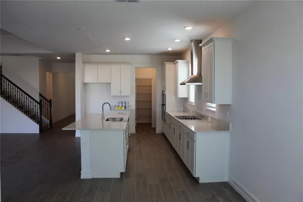 a kitchen with stainless steel appliances granite countertop a refrigerator a sink and a stove top oven