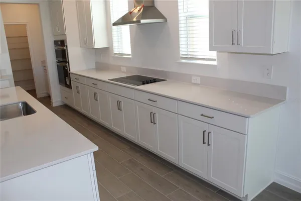 a kitchen with white cabinets and window