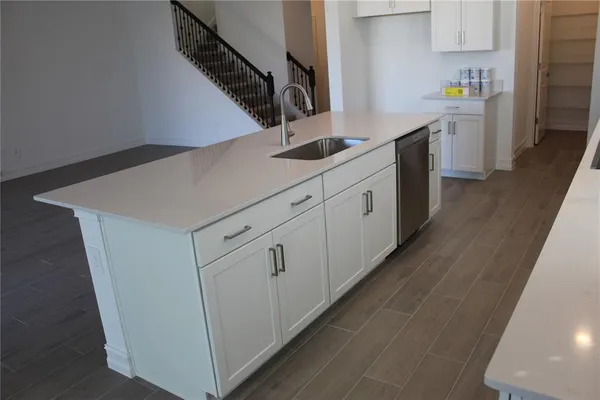 a kitchen with white cabinets and sink