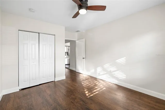 a view of empty room with wooden floor