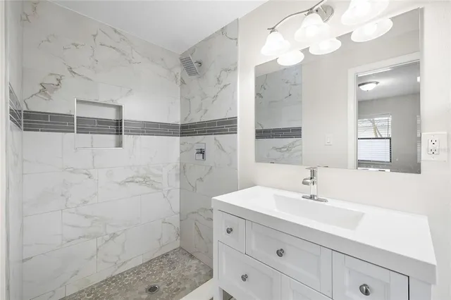 a bathroom with a sink a mirror and a shower