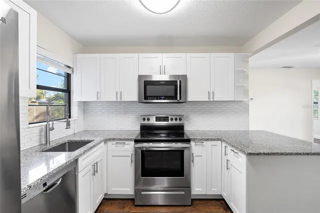 a kitchen with granite countertop a stove and a sink