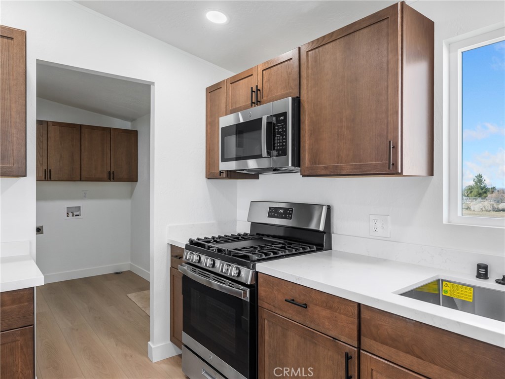11623 Desert View Road Pinon Hills, CA 92372 - Photo 12 of 47 a kitchen with stainless steel appliances a stove a microwave and cabinets