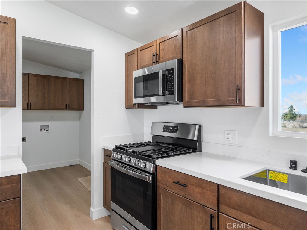 11623 Desert View Road Pinon Hills, CA 92372 - Photo 12 of 47 a kitchen with stainless steel appliances a stove a microwave and cabinets