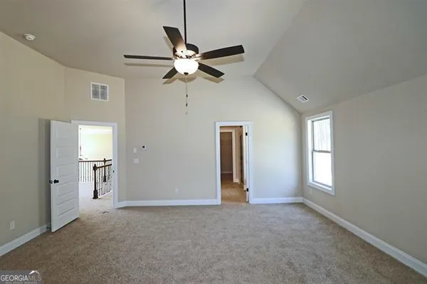 a view of empty room with window and ceiling fan