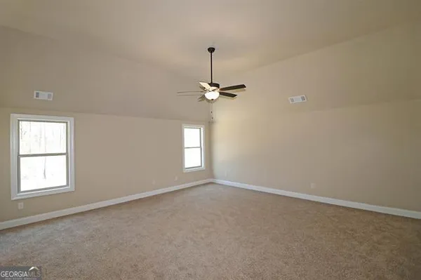 an empty room with windows and fan