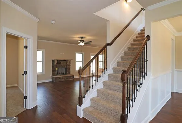 a view of a hallway with wooden floor and stairs