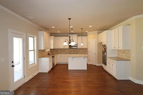 a kitchen with white cabinets and counter space