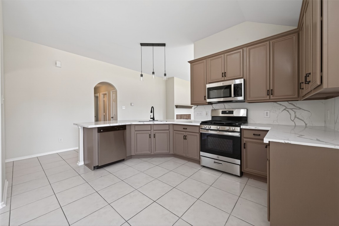 19902 Chaste Tree Lane Humble, TX 77338 - Photo 12 of 43 a kitchen with stainless steel appliances cabinets a sink and a stove