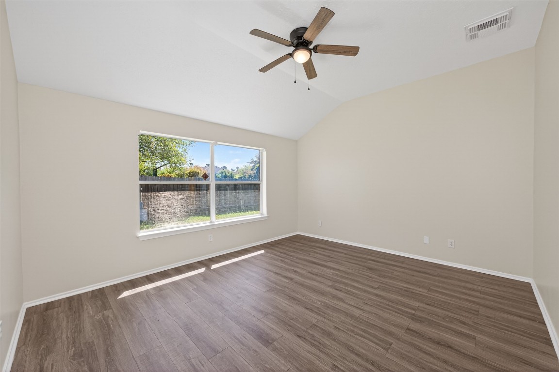 19902 Chaste Tree Lane Humble, TX 77338 - Photo 21 of 43 an empty room with wooden floor fan and windows