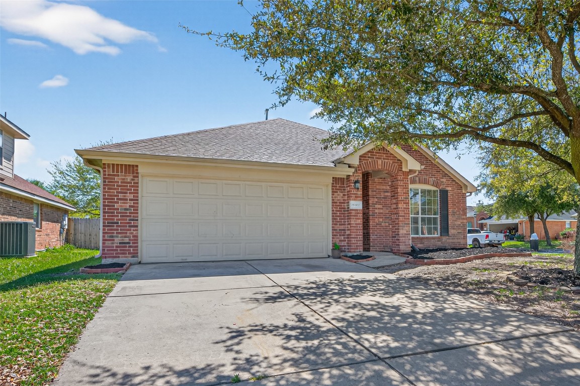19902 Chaste Tree Lane Humble, TX 77338 - Photo 3 of 43 a front view of a house with a yard and garage