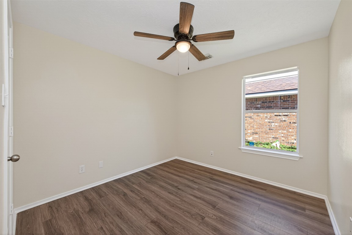 19902 Chaste Tree Lane Humble, TX 77338 - Photo 36 of 43 an empty room with wooden floor ceiling fan and windows