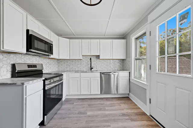 a kitchen with stainless steel appliances granite countertop a stove and a microwave