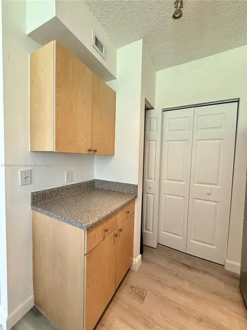 a kitchen with a sink a cabinets and a window