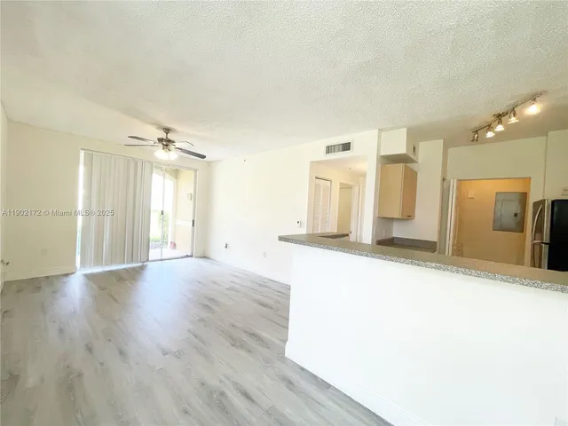 a view of a kitchen with wooden floor and a kitchen